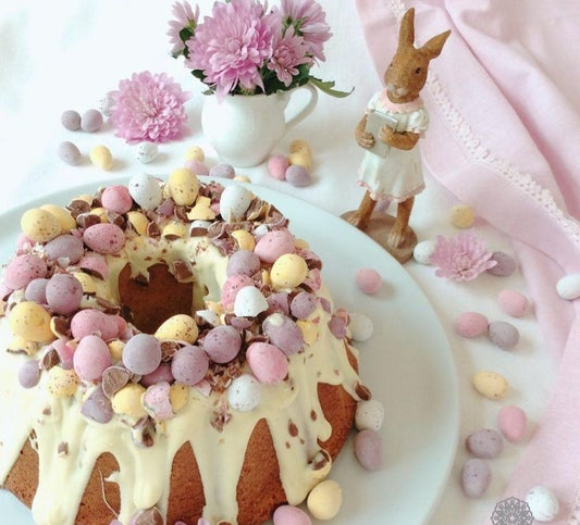 Gâteau de Pâques aux noix et raisins secs, décoré de chocolat blanc et d'œufs en chocolat.
